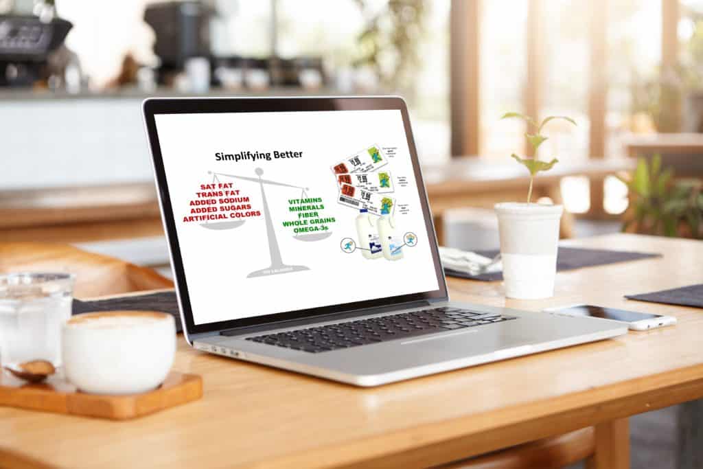 Open laptop on a wood table shows a slide from Julie's presentation highlighting the nutrients Guiding Stars focuses on